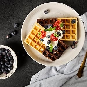 Gaufres dans une assiette avec cème fouettée, fruits rouges vue de dessus