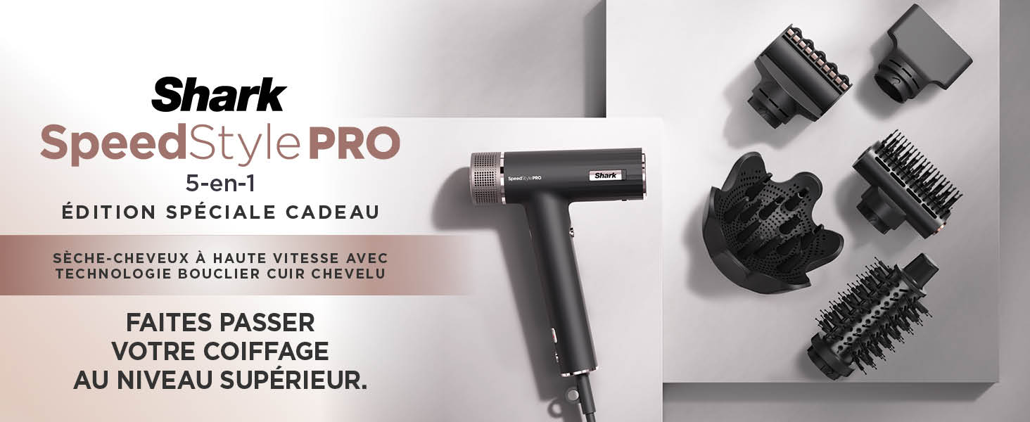 Le texte indique « Shark SpeedStyle PRO ». Outil de coiffure professionnel présenté en finition gris foncé/noir avec plusieurs accessoires et têtes de brosse visibles.