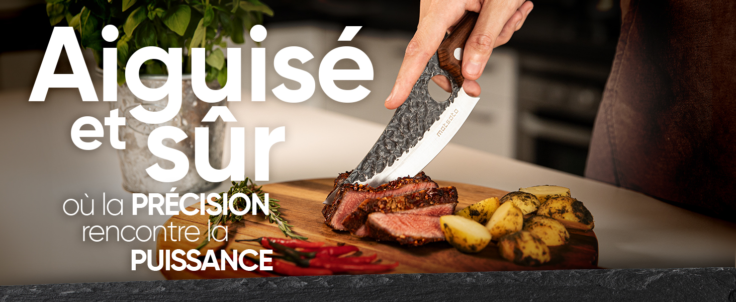 À la main, utilisez un grand couteau de cuisine texturé pour trancher un bifteck cuit sur une planche de bois. Légumes rôtis et sauce visibles à côté de la viande.