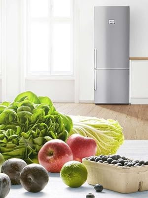 Grand réfrigérateur argenté dans un décor de cuisine lumineux avec des produits frais exposés au premier plan, notamment des pommes, de la laitue et d'autres fruits.