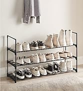 Étagère à chaussures en métal à trois niveaux avec cadre noir présentant plusieurs paires de baskets et de bottes décontractées de couleurs neutres, organisées sur des étagères en filet contre un mur lumineux