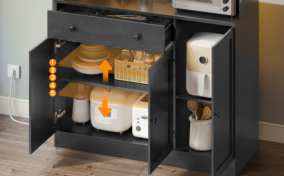 Armoire intérieure foncée avec système de rangement coulissant, comprenant des compartiments organisés pour les articles de cuisine et des indicateurs de direction orange.